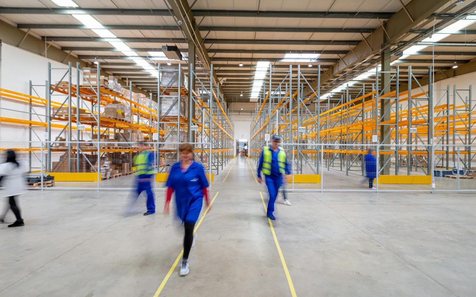 Workers walking through warehouse aisle